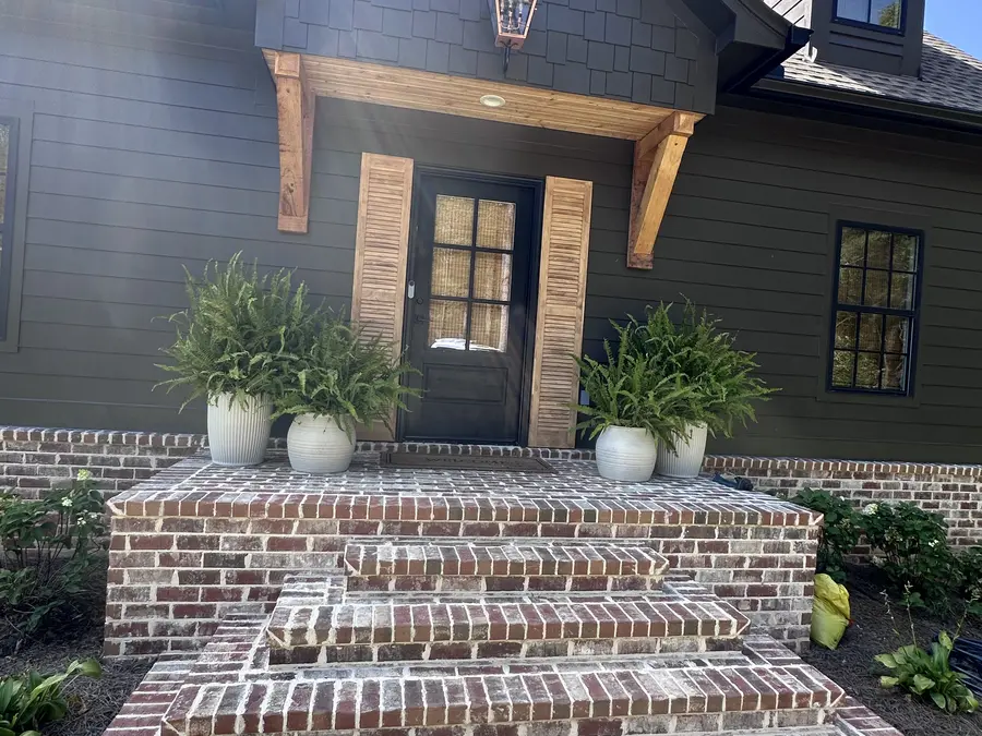 Custom front entry with cedar accents and brick steps by Still Oak Homes