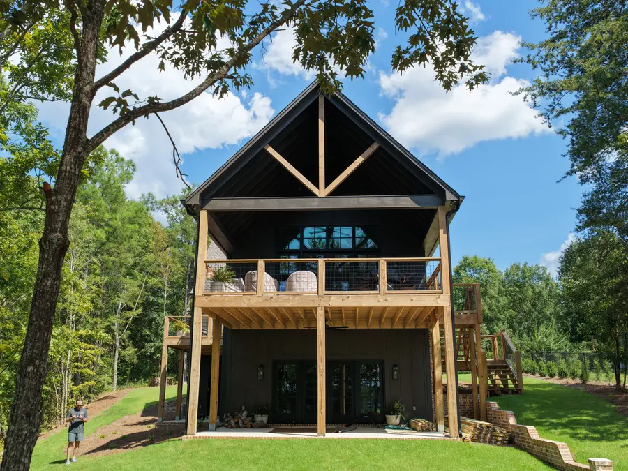 Rear elevation of a custom lake house with two-story porch by Still Oak Homes